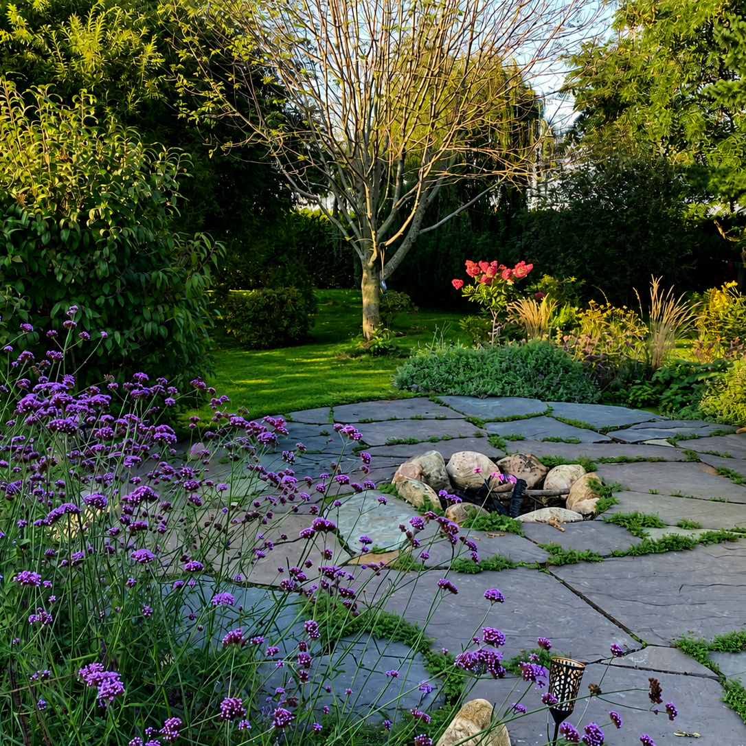 Création Nature – Jardin paysager avec terrasse en dalles naturelles, foyer extérieur, vivaces fleuries et aménagement horticole personnalisé à Narbonne. Jardin aménagé avec terrasse en pierre naturelle, foyer extérieur intégré, massifs de vivaces colorées, graminées et espace vert